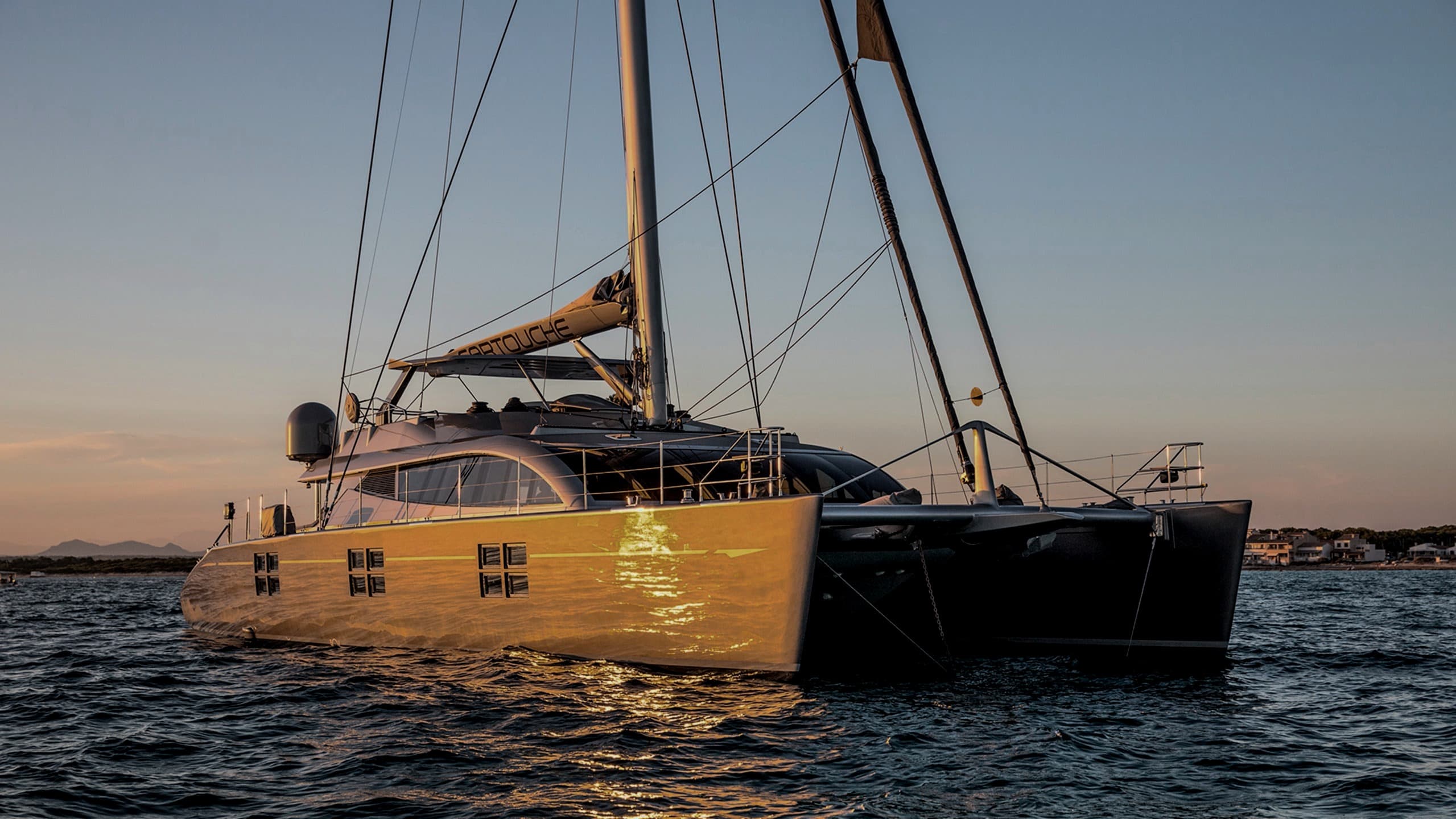 Cartouche — Blue Coast 95 sailing catamaran at golden hour